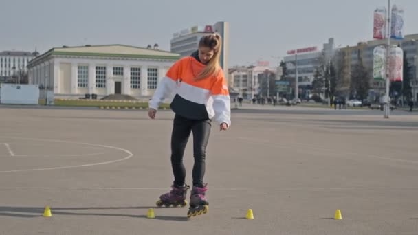 Mujer joven monta en patines y gira en cámara lenta. Patinaje femenino — Vídeos de Stock