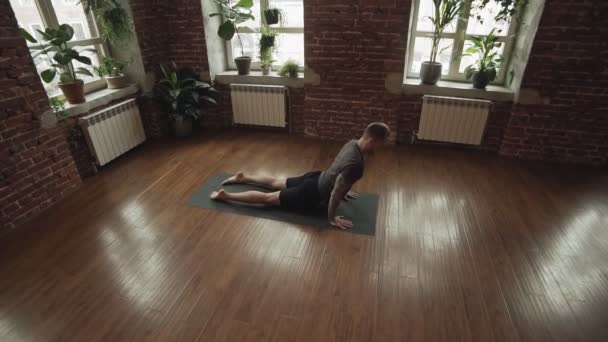 Attraktiv man gör yoga pose i gymmet. Man Practice yoga pose i studion — Stockvideo