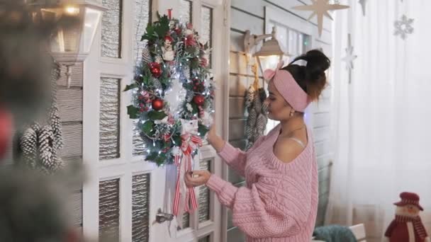 Menina Bonita Pulôver Rosa Pendurado Grinalda Natal Com Bolas Porta — Vídeo de Stock