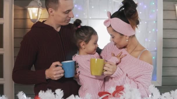 파우치에서 포옹하고 말하고 슬로우 모션으로 크리스마스 저녁에 초콜릿을 즐기는 가족의 — 비디오