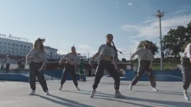 Vitebsk, Beyaz Rusya - 1 Temmuz 2019: Gün batımında şehirde funky hip hop hareketlerinin keyfini çıkaran sokak dansçısı kızlar. Yaz aylarında gösteri yapan hip-hop sokak dansçıları grubu.