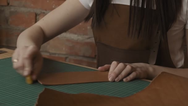 专业的女性工匠手抛光一块皮革 工匠为钱包的皮革进行焊接 特写视图 — 图库视频影像