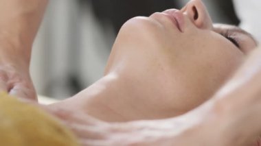 Spa'da masaj sırasında kadının yüzünün yakın çekim. Güzellik tedavi konsepti. Spa'da yüz masajı alan rahat kadın.