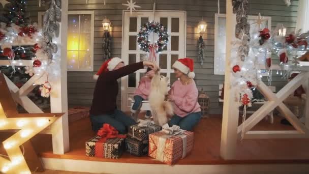 Gelukkige Familie Met Kleine Dochter Hond Zittend Veranda Met Kerstboom — Stockvideo