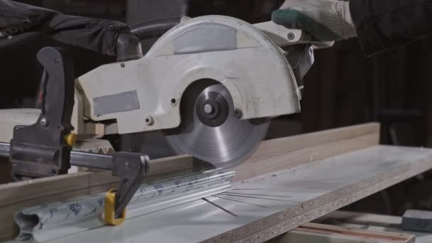 円形の鋸で金属棒を切断する大工 大工ワークショップ テーブル円形の鋸切断部品を持つ人のクローズアップ — ストック動画