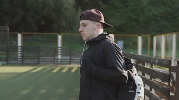 Young Man Walking Training Sunny Morning Sportsman Cap Headphones Backpack — Stock Video
