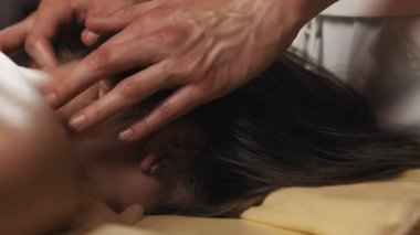 Spa'da boyun masajı yaptıran genç kadın. Kız yağ masajı alıyor. Erkek ellerinin yakın çekim kadın profesyonel masaj yapıyor. 4k, Uhd
