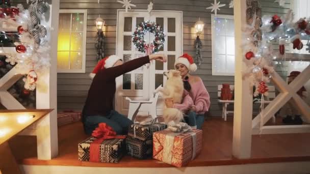 Família Jovem Com Filhinha Cachorro Sentado Alpendre Com Árvore Natal — Vídeo de Stock