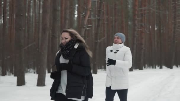 Winteraufnahme Eines Jungen Paares Das Bei Schneetreiben Zeitlupe Kiefernwald Rennt — Stockvideo