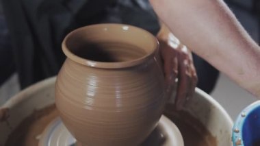 Ellerin yakın çekim yavaşça kilden doğru şekilli el yapımı oluşturun. Çömlekçi, çömlekçi tekerleğinde veya çömlekçi torna çömlekçilerinde ürün oluşturur.