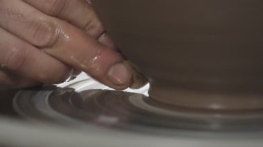 Çömlekçi eller yavaşça kilden sürahi oluşturun. Potter çömlekçi tekerleğinde ürün oluşturur. Yakın çekim görünüm. El yapımı. Zanaat.