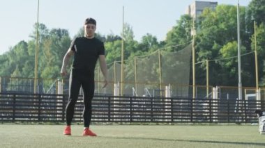 Siyah spor giyen adam koşudan önce bacak kaslarını ısıtıyor. Turuncu ayakkabılar. Sportif adam güneşli sabah fitness eğitimi öncesi germe. Copyspace ile tam uzunlukta çekim
