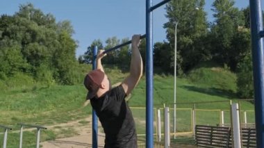 Pull-up kuvvet eğitim egzersiz. Genç adam güneşli sabah yatay barda yukarı çekiyor. Dışarıda egzersiz. 4k, Uhd