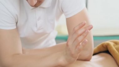 Erkek masör masaj yapıyor. Spa salonunda yağ masajı alan genç kadın