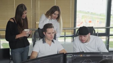 Ofiste konuşan genç çalışanlar. Birlikte çalışan iş arkadaşları bilgisayar projesini tartışırlar. Takım çalışması. Beyin fırtınası. 4k orta atış, Uhd