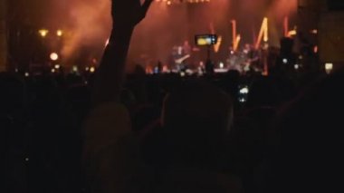 4k, Uhd gece rock konserinde ellerin silueti. İnsanlar akıllı telefonlarla el sallıyor. Canlı müzik konseri.