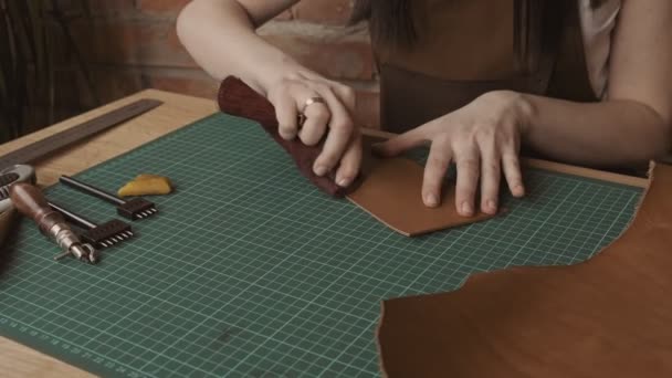女性工匠手抛光一块皮革 工匠为钱包的皮革进行焊接 特写视图 — 图库视频影像
