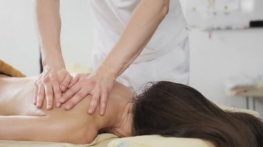 Esmer kadın masaj masasında yatan spa sırt masajı sırasında rahatlatıcı. Spa'da masaj yaptıran genç kadın. Orta atış