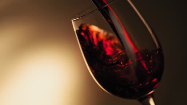 左側のコピースペースでボトルからゴブレットに赤ワインを注ぐのスローモーション 赤ワインのクローズアップは ガラスの美しい波を形成します 暗い背景にガラスに注ぐワイン — ストック動画