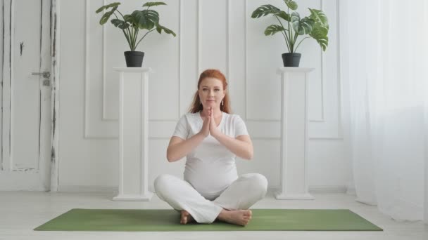 Framtida mor utövar yoga. Ung gravid kvinna gör stretching hemma — Stockvideo