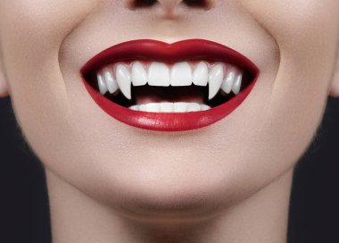 Sexy Female Vampire Lips. Monster Smile. Halloween Style with Red Blood Makeup Lip. Masquerade Look with Terrible Fags on Black Background clipart