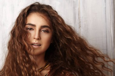 Uzun kıvırcık saç modeli, moda takı uzun esmer saçlı güzel genç kadın. Seksi kız vogue tarzı. Kadın yüzü güzel Arap Güzellik Portresi. Hint tarzı kıyafetler, uzun elbise