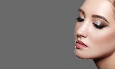 Profesyonel makyajlı güzel bir kadın. Moda Göz Makyajı, Kusursuz Kaşlar, Parlak Cilt. Parlak Moda Bak