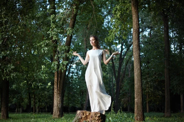 Schöne Frau posiert wie eine Göttin im weißen langen Kleid in der Natur. Boho-Stil, Seelenruhe, Wohlbefinden. Freiheit und Entspannung — Stockfoto