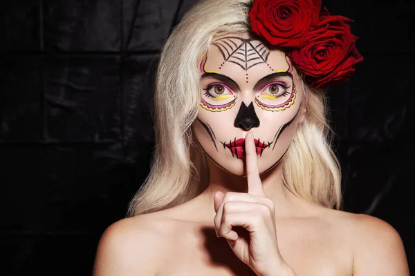 Halloween smink stil. Blond modell Bär Sugar Skull Makeup med röda rosor. Santa Muerte-konceptet. Tystnad Gesture — Stockfoto