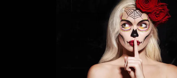 Hermoso estilo de maquillaje de Halloween. Modelo rubio Use maquillaje de cráneo de azúcar con rosas rojas. Concepto de Santa Muerte —  Fotos de Stock