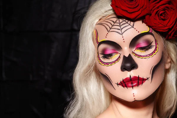 Wunderschönes Halloween-Make-up. Das blonde Model trägt Zuckerschädel-Make-up mit roten Rosen. Santa-Muerte-Konzept — Stockfoto