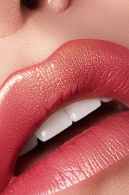 Makro yakın plan göz kamaştırıcı, parlak kırmızı dudaklar altın parıltısıyla süslenmiş. Makro kadın yüzü parçası. Seksi dudak makyajı, lüks bir yüz.