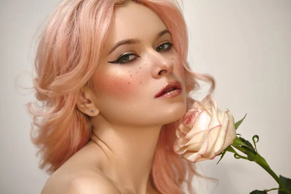 Soft-Girl Style with Trend Pink Flying Hair, Fashion Make-up. Woman Face with Fake Freckles and Rose Flowers. Blonde Female Model with perfect Fresh Clean Skin, Blush Rouge