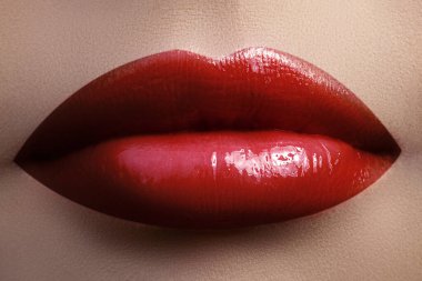 Macro closeup shot of passionate red lips. Dark red lipstick with gloss makeup. Vamp style make-up. Perfect for date, Valentines day or Christmas holiday. Concept for Beauty and Cosmetology Industry.