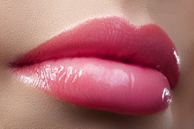 Macro closeup shot of passionate fresh pink lips. Bright pink lipstick with lip gloss makeup. Daily style make-up. Perfect for date, Valentines day or holiday. For Beauty and Cosmetology Industry.