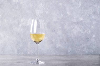 Bardak beyaz taş zemin üzerine beyaz şarap. Kopya alanı