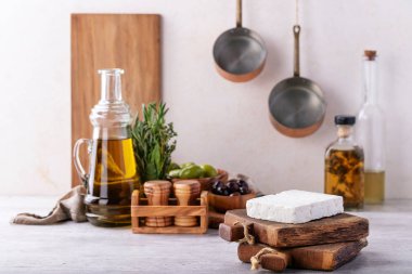 Geleneksel Yunan meze keçi peynir otlar, yeşil ve siyah zeytin ve sızma zeytinyağı ile gri bir arka plan üzerinde servis.
