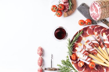 Tedavi et yelpazesi üzerinde beyaz artalanları grisini, jambon, salam, domates, biberiye ve kırmızı şarap ile görev yaptı. Üstten görünüm. Kopya alanı