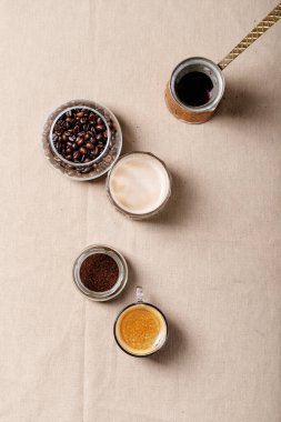 Kahverengi örtülü tarçın kaplı cam bardaklarda taze kahve. Üst manzara, düz uzanma