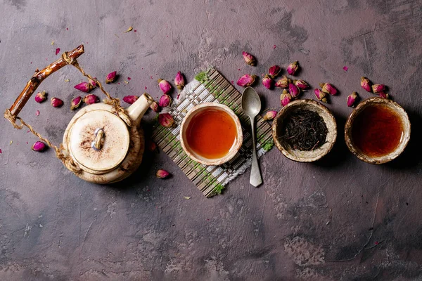 Czarna Herbata Ceramicznym Kubku Ceramicznym Czajnikiem Płatkami Róż Brązowym Tle — Zdjęcie stockowe