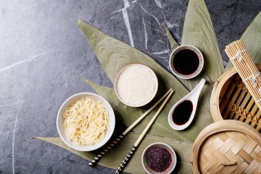 Bambu yapraklı erişte ve pilav, teriyaki sosu, soya sosu, ahşap buharlı buhar ve yemek çubukları. Üst manzara, düz yatış. Boşluğu kopyala
