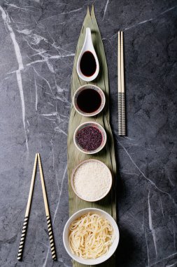 Bambu yapraklı erişte ve pilav, teriyaki sosu, soya sosu, ahşap buharlı buhar ve yemek çubukları. Üst manzara, düz yatış. Boşluğu kopyala