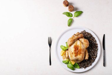 Tuz, biber, fesleğen, kızarmış limon, çatal ve çatalla servis edilen bütün tavuk ve esmer pirinci pişirdim. Üst manzara, düz yatış. Boşluğu kopyala