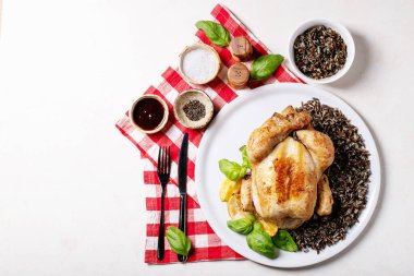 Tuz, biber, fesleğen, kızarmış limon, çatal ve çatalla servis edilen bütün tavuk ve esmer pirinci pişirdim. Üst manzara, düz yatış. Boşluğu kopyala