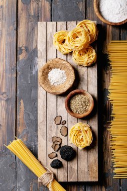 Yer mantarı ile servis edilen ev yapımı yumurta makarna, mantar ezmeli yağ ve saltodan ahşap arka plan. Yeni çiğ gıda konsepti. Üst manzara, düz yatış. Boşluğu kopyala