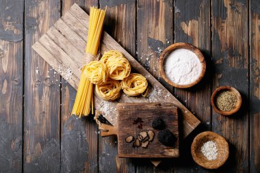 Yer mantarı, trüf yağı ve tuzlu ev yapımı yumurtalı makarna. Ahşap arka planda yeni çiğ gıda kavramı. Üst manzara, düz yatış. Boşluğu kopyala