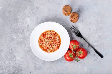 Pişmiş spagetti bolonez, siyah biberli ve beyaz desenli beyaz seramik tabakta saslt. Üst manzara, düz yatış. Boşluğu kopyala