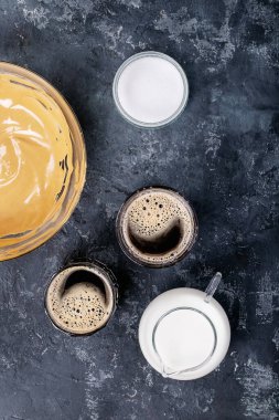 Dalgona köpüklü kahve trend Kore kahvesi üç farklı cam fincanda köpüklü kahve. Gri beton arka plan. Üst manzara, düz yatış. Boşluğu kopyala