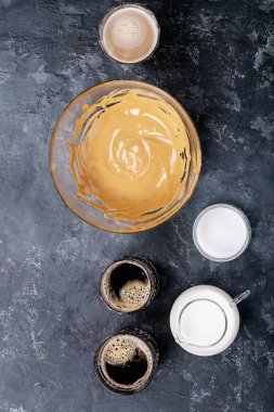 Dalgona köpüklü kahve trend Kore kahvesi üç farklı cam fincanda köpüklü kahve. Gri beton arka plan. Üst manzara, düz yatış. Boşluğu kopyala