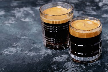 Dalgona köpüklü kahve trend Kore kahvesi üç farklı cam fincanda köpüklü kahve. Gri beton arkaplan.